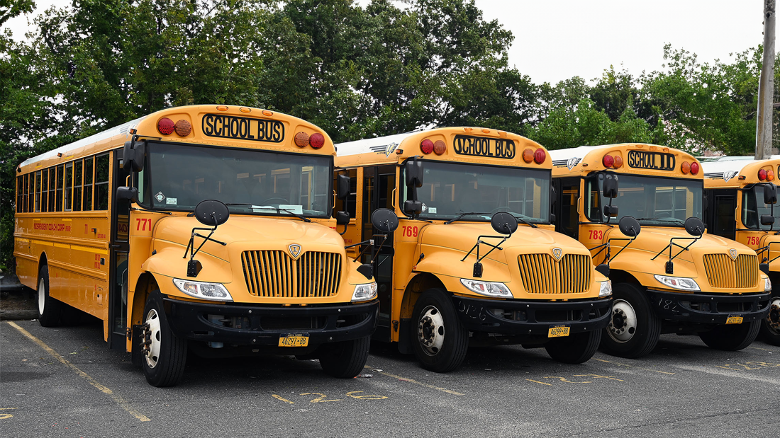 Independent Coach Corporation school buses and vans lined up at the yard in Inwood, New York.